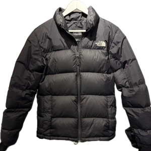 Svart pufferjacka från The North Face - Säljer en svart pufferjacka (dun) från  North Face i mycket bra skick. Jackan är perfekt för kalla dagar med tjock vaddering. 