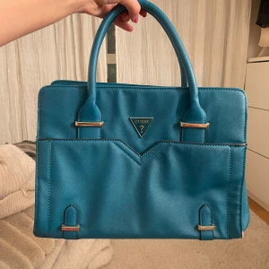 handväska från Guess - Köpt på sellpy, har en del små defekter men inget som har stört mig eller syns när man väl bär den, skriv för fler bilder💓 finns dustbag och ett längre band