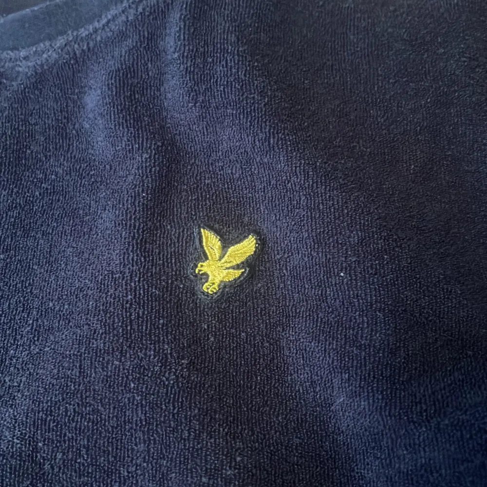 Säljer en snygg mörkblå tröja från Lyle & Scott med deras ikoniska gula logga broderad på bröstet. Tröjan är i bra skick och perfekt för både vardag och lite finare tillfällen. Den är mjuk och bekväm, idealisk för höst och vinter.. Tröjor & Koftor.