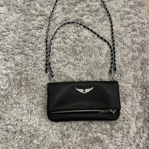 Zadig väska💕 - Snygg svart Zadig i skinn med kedjedetaljer på axelremmarna. Perfekt för en utekväll eller fest. Den är helt ny bara andvänd ca 2 gånger. Både de korta och långa banden till den medföljer💕💕💕🥰