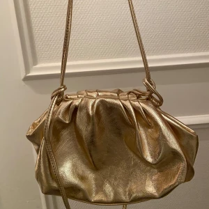 Guldig kuvertväska - Säljer en superfin guldig kuvertväska, finns justerbara axelremsband som går att lägga in i väskan🌼 Köpte från even&odd och är slutsåld 