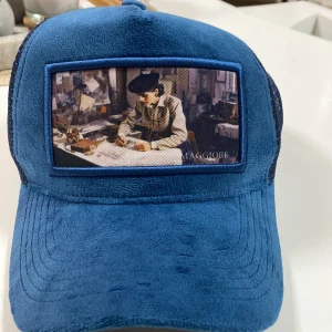  keps  - Säljer en cool blå keps med ett konstmotiv på framsidan. Kepsen har ett nätmaterial på baksidan för bra ventilation och en justerbar rem för perfekt passform. Perfekt för sommarens alla äventyr!