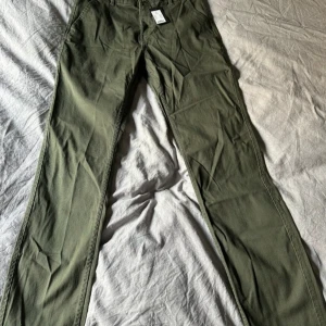 Gröna chinos - Säljer ett par snygga gröna chinos. Byxorna är nya med lappar och har en klassisk stil som funkar året runt. Passar perfekt till en avslappnad look eller med en skjorta för en mer uppklädd stil.