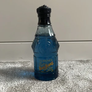 Versace Blue Jeans Eau de Toilette - Säljer en flaska Versace Blue Jeans Eau de Toilette,ungefär 72 ml kvar . Den har en cool blå flaska med ett unikt mönster och kommer i en matchande blå metallburk. Doften är aromatisk och fräscht kryddig med inslag av trä, citrus och vanilj. Perfekt för dig som vill ha en fräsch och maskulin doft. Passar både till vardags och fest!