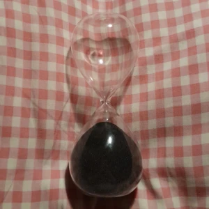 Timglas - Ett timglas med svart sand, ungefär 15 min.