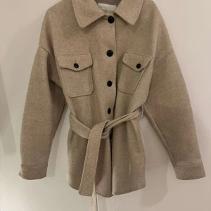Beige kappa - Kappa från Nelly Använd fåtal gånger  Storlek S Köptes för 600kr