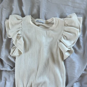 Vit/beige topp - Söt topp från Zara med puffärm. Säljer pga ingen användning längre och lite för stor. Använd några gånger men ff bra skick. Jättefin till vardags och stor användning.