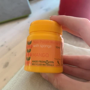 Nagellacksborttagare med svamp - Mango - Säljer en nagellacksborttagare med svamp i en praktisk burk. Den har en fräsch doft av mango och är tillverkad av 99% återvunnet material. Perfekt för att snabbt och enkelt ta bort nagellack utan att behöva använda bomullspads.