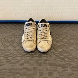 Diesel Skor  - Tja säljer ett par schyssta vita Diesel skor. Skick 8/10 lite smutsiga men lite av smutset är också designe. Storlek 43 skriv gärna vid minsta fundering. Priset kan också diskuteras.