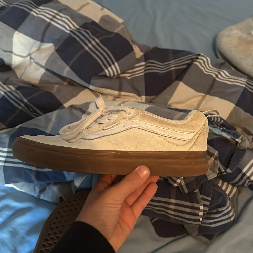 Säljer ett par vita Vans sneakers i storlek herr 38. Skorna är i mocka och har en snygg brun sula. De är i bra skick och har snörning. Perfekta för vår och sommar!. Skor.