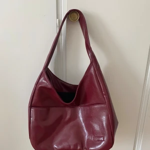 Vinröd väska - Köpt från Nuvelle men aldrig använt. Superfin men den luktar lite pga fejklädret. Rymlig och superfin färg nu till hösten 🙏