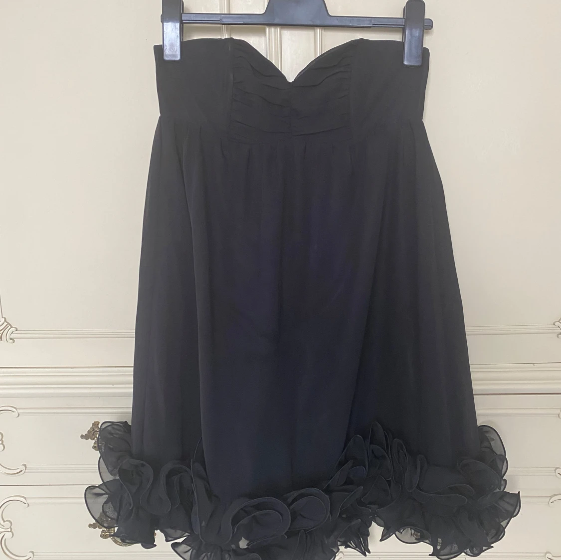 Svart axelbandslös klänning med volang