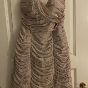 Drapperad fodralklänning - Beige drapperad klänning, använd ett fåtal gånger. Perfekt till höstens festligheter 
