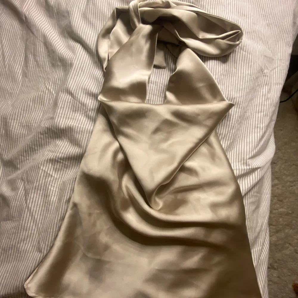 Supersnygg satin topp från zara(slutsåld) Säljer en supersnygg topp från zara som man knyter runt halsen med öppen rygg. där bak har den en liten defekt men syns inte, se bild. . Puserot.