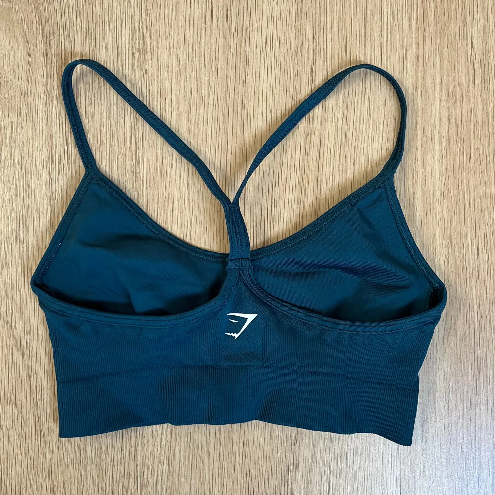 Grönt träningsset med sport-bh och tights från Gymshark. Bra skick, använd få gånger. Färgen heter ”Winter teal” och är grönare i verkligheten än på bilden. Från kollektionen Sweat seamless. Sport-bh:n är liten i storleken. Orginalpris: 1248kr. Sportswear.