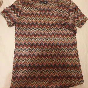 T-shirt - Super fin t-shirt med massa färger.Den är öppen från ryggen och är i storlek s funkar som m ochså.Säljer för 50