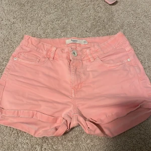 Rosa shorts från Lindex - Säljer ett par snygga rosa shorts från Lindex i storlek EUR 146. De har en normal passform med knappar och dragkedja framtill. Shortsen har fickor både fram och bak, vilket är superpraktiskt. Perfekta för sommaren ❤️