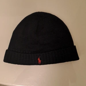 Ralph lauren mössa - Mycket bra skick. Perfekt för höst och vintern. Lite trå som hänger ut från tagen. Kom med prisförslag. Ordinarie: 700kr jag säljer för 250kr