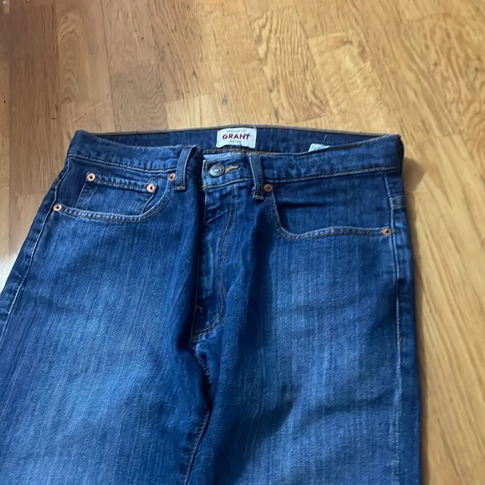 Säljer ett par klassiska blå jeans från Grant. De har en straight passform och är tillverkade i slitstarkt denim. Jeansen har fem fickor och en knappgylf. Perfekta för vardagsbruk!. Jeans & Byxor.