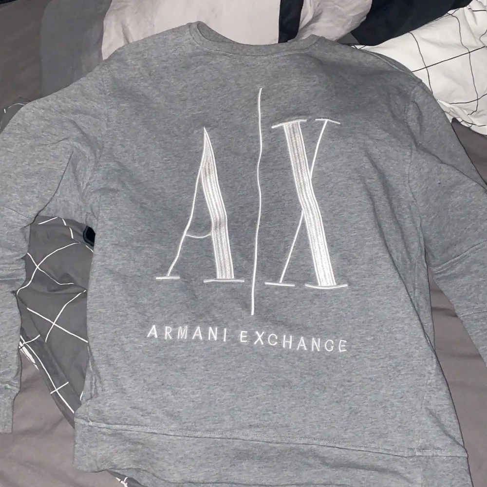 Säljer en snygg grå tröja från Armani Exchange. Den har en stor A|X-logga på framsidan och är i storlek M. Perfekt för en casual look och passar till alla tillfällen. Tröjan är i bra skick och superbekväm att ha på sig.. Tröjor & Koftor.