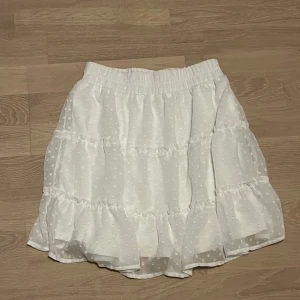 Vit kjol från FB Sister - En vit kjol med små vita prickar från FB Sister i storlek S. Har använt ungefär 3 gånger och är i bra skick. Perfekt till sommaren!