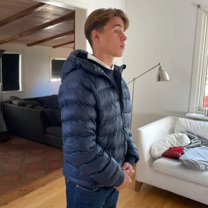 Peak performance jacka - Tomic Insulated Hood Jacket. Jackan är i väldigt bra skick, förutom ett väldigt litet hål på ärmen, inget man tänker på och kan lätt lagas. Jackan är köpt på peak performance hemsida med nypris på 3200kr. Hör av dig vid minsta fråga