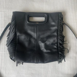 Äkta Maje väska - Snygg Maje handväska 🤩 💗Svart med gulddetaljer  💗Har används sparsamt 💗Fint skick men några små skavanker (skriv för fler bilder) 💗Stl: M 💗Axelbandet går att ta av, 81 cm, juserbart 💗Äkta skin 💗Mått : 20 bredd, 23 cm längd, 6 cm vid 💗Nypris: 3295