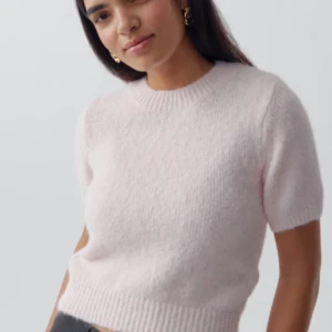 Ljusrosa stickad tröja - Säljer en söt ljusrosa stickad tröja med korta ärmar. Perfekt för en mysig och stilren look. Tröjan har en rund halsringning och ribbade kanter som ger en fin passform. Passar bra till både jeans och kjol. Skriv vid frågor och bilder❤️