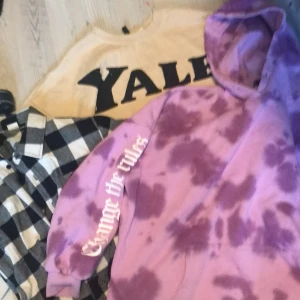 H&M  - Säljer en cool lila batikmönstrad hoodie med texten 'Change the rules' på ärmen. Perfekt för en avslappnad stil med en unik touch. Hoodien har en klassisk passform och en stor huva.
