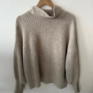 Stickad tröja  - Beige stickad tröja, använt skick. Fina detaljer och har lite lös krage som man kan styla snyggt. Otroligt skön och bekväm stickad tröja, säljer vidare till någon som har mer användning av den.