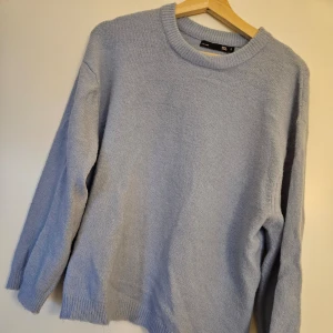 Ljusblå stickad tröja från Lager 157 - Säljer en mysig ljusblå stickad tröja från lager157. Tröjan har en rund halsringning och långa ärmar, perfekt för kyliga dagar. Den är enkel och stilren, vilket gör den lätt att matcha med olika outfits. Perfekt för dig som vill ha något bekvämt och snyggt i garderoben.