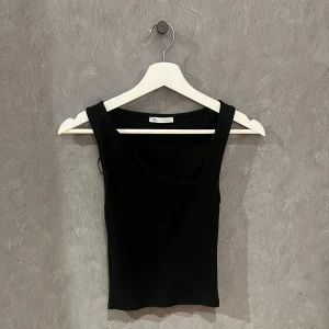 Svart linnetopp från Zara - Snygg svart linnetopp från Zara med breda axelband. Har en sne ringning fram 