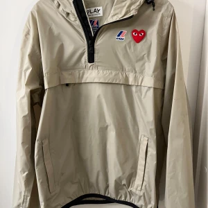 Beige vindjacka från Comme des Garçons - Snygg beige vindjacka med huva från Comme des Garçons. Helt perfekt skick! Storlek M inga konstigheter. Hör av er vid andra frågor eller funderingar! 