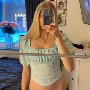 Ljusblå blommig korsettopp - Säljer denna super söta blåa blus ifrån Gina tricot som jag köpte för några år sedan men som endast används ett fåtal gånger och inte har några  tecken på användning :)