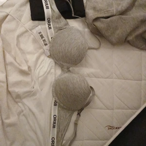 Grå bh från Orui - Snygg grå bh från Orui i mjukt material med 95% viskos och 5% elastan. Den har en enkel design med justerbara axelband och en bekväm passform. Perfekt för vardagsbruk.