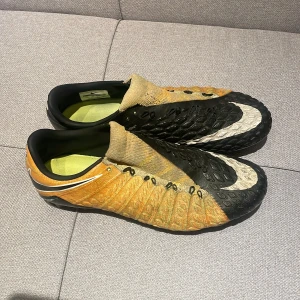 Nike fotbollsskor Hypervenom - Säljer ett par Nike fotbollsskor i svart och orange . De är i storlek 41 och är i 6,5/10 skick. De är välanvända men är fortfarande i bra skick. Har tyvär inga snören eller box till dem. Pris kan diskuteras!