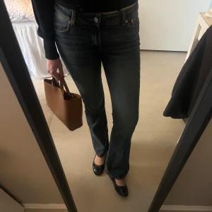 Blå bootcut jeans - Snygga lågmidjade blå bootcut jeans med låg midja från Junkyard. Perfekta för en avslappnad stil eller perfekt till fest. Passar bra med alla typer av skor. 