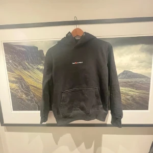  Saint Laurent hoodie - Säljer en stilren svart hoodie från Saint Laurent med en klassisk känguruficka framtill. Hoodien har en liten logotyp på bröstet och är perfekt för en avslappnad look. Passar bra till både jeans och joggers. påse finns även