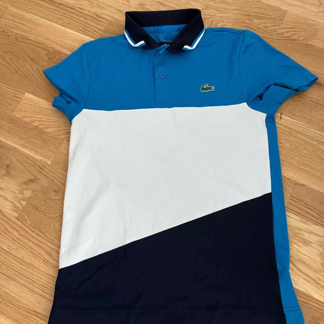 Blå och vit pikétröja från Lacoste