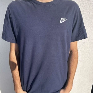Marinblå Nike T-Shirt - Blå Nike t-shirt i storlek M. Superbra skick och perfekt till vardags men även andra tillfällen. Modellen har vanligen storlek M/L för referens