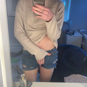 Blå jeansshorts med slitningar - Snygga blå jeansshorts med slitningar och råa kanter. Perfekta för en avslappnad stil. De har en klassisk femficksdesign och knappgylf. Storlek 160 men passar mig som har xs-s