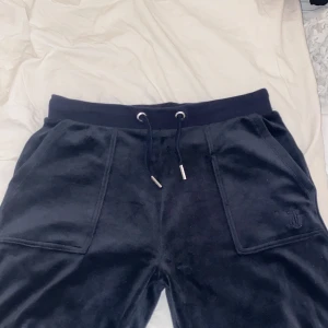 Juicy Couture byxor  - Snygga märkblåa jättesköna mjukisbyxor från Juicy Couture. Byxorna har en mjuk och bekväm känsla. De ser lite svarta ut på bilden men det är för att det är mörkt, men de är mörkblåa. Inga defekter alls och priset kan diskuteras. Köptes för 1100kr säljer för 300kr