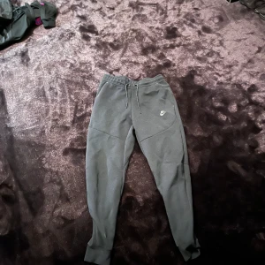 Svarta Nike Tech Byxor - Säljer ett par svarta Nike Tech byxor för att de är för små, storlek S, Skick 7/10 dom är ganska noppiga på rumpan.