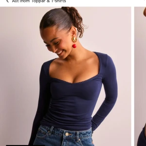 Mörkblå långärmad topp - Snygg mörkblå långärmad topp med djup v-ringning. Perfekt för en stilren look. Passar bra till jeans eller kjol.
