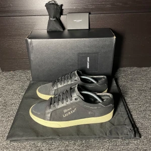  Saint Laurent - Saint Laurent sneakers i storlek 41 fitts 42, skick (bra) lite solblekt, alla tillbehör medföljer så som box dustbag extrasnören (lite använda) och kort, 