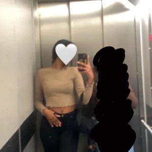 Beige croppad topp - Säljer en beige croppad topp med långa ärmar. Perfekt för en trendig look. Passar bra till både jeans och kjol.