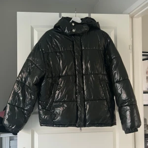 Mörkgrön jacka - Mörkgrön vinterjacka, glansig jacka med luva från Weekday. Köpt på herr avdelningen men passar både dam och herr, jag har ju haft den :)