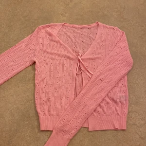 Rosa ribbad kofta - Söt rosa kofta med ribbad struktur och knytning framtill. I storlek xs! Skriv om due intresserad!❤️❤️har aldrig använt den, ny utan prislapp.