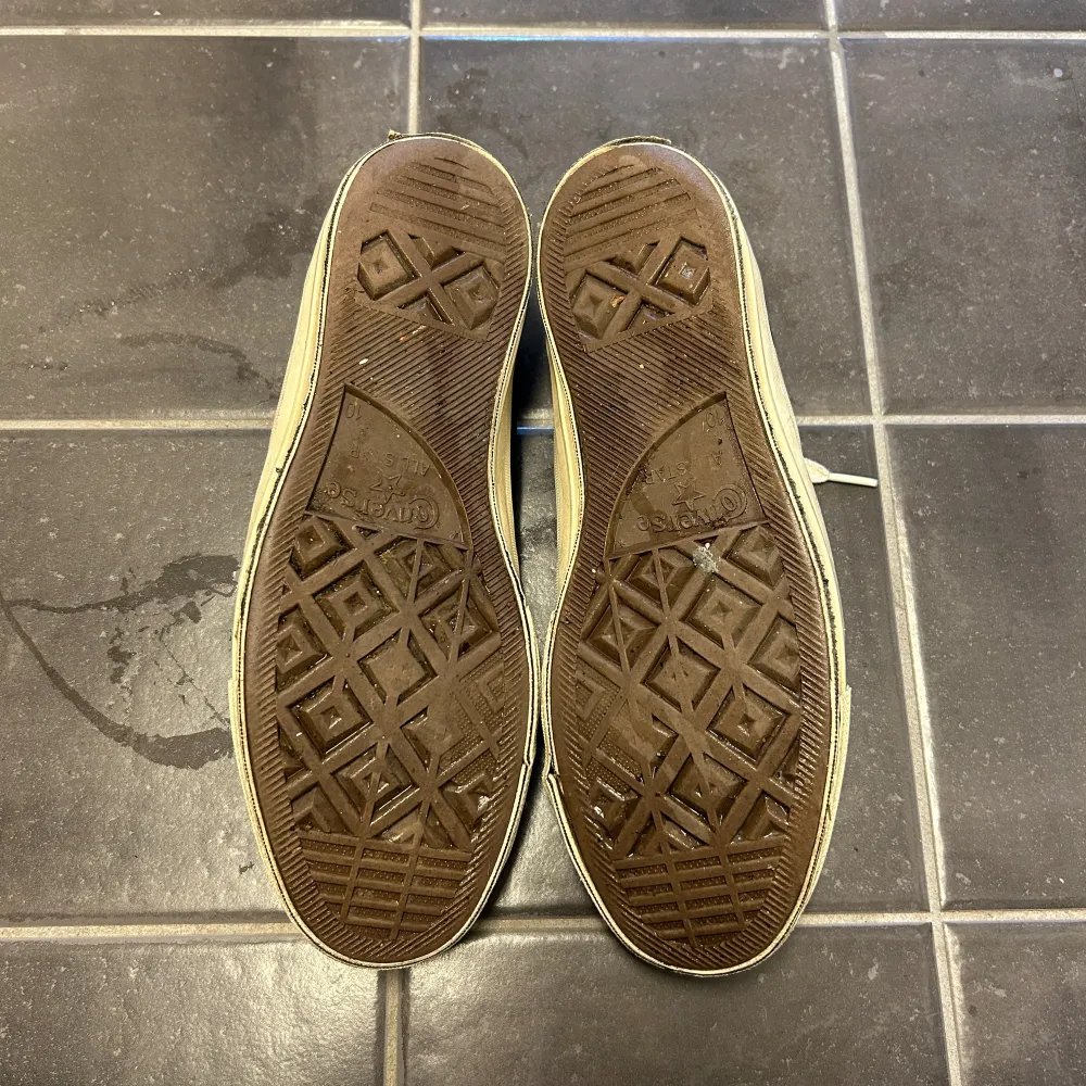 Säljer ett par svarta Converse sneakers med en röd hjärtdetalj på sidan. Skorna har vita snören och en klassisk gummisula. Perfekta för en avslappnad stil.. Kengät.