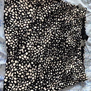 Svart och vit mönstrad kjol från H&M - Snygg svart kjol med vita mönster från H&M. Kjolen har en kort längd 